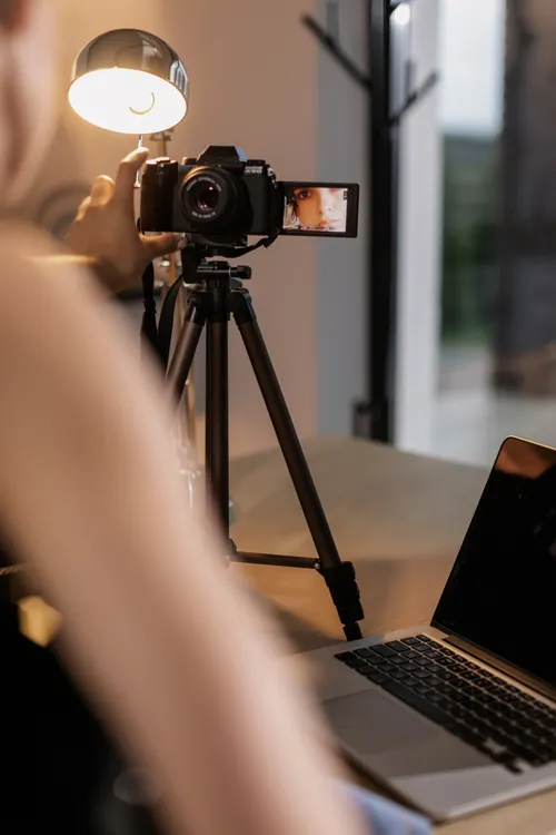 Content creator filming a product video beside a laptop